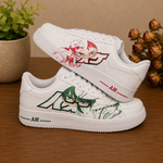 A pair of white low-top sneakers with anime character graphics, displayed on a wooden surface with a potted plant and dried flowers in the background.