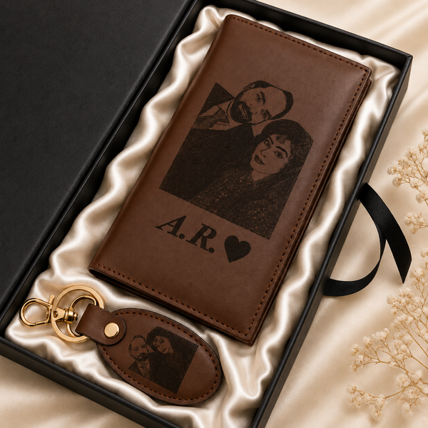 A personalized brown leather wallet and matching keychain presented in a black gift box with satin lining. The wallet and keychain are engraved with a couple's portrait photo and the initials 'A.