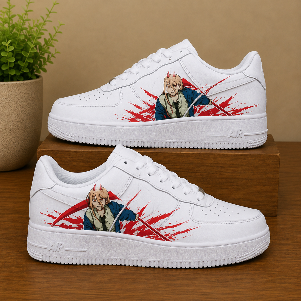 A pair of white low-top sneakers with anime character graphics and red paint-splatter details, displayed on a wooden surface with a potted plant in the background.