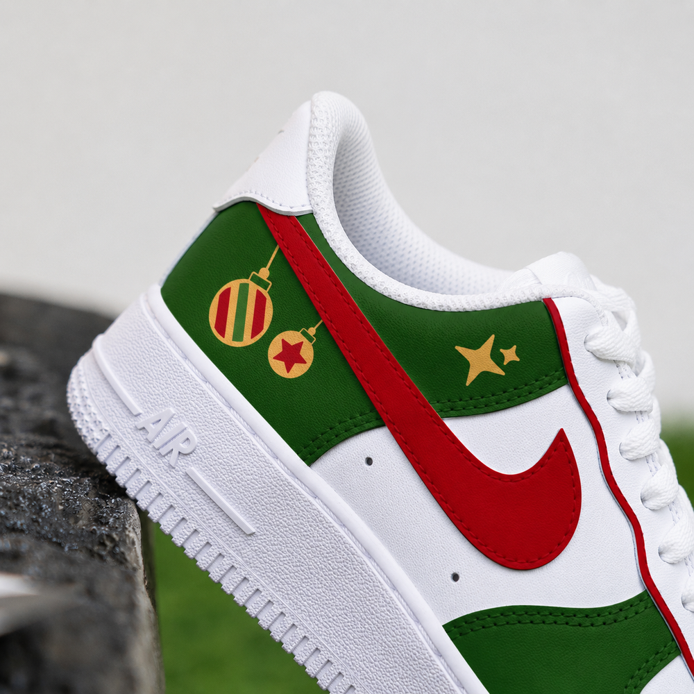 A close-up of a white Nike Air Force 1 sneaker with green and red holiday-themed overlays, featuring gold stars and ornaments on the side.