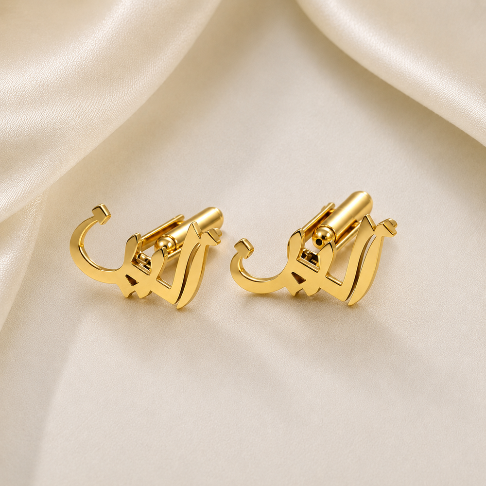 A pair of gold-toned clip-on hoop earrings with a sculptural, abstract curved design, displayed on a draped cream satin fabric background.